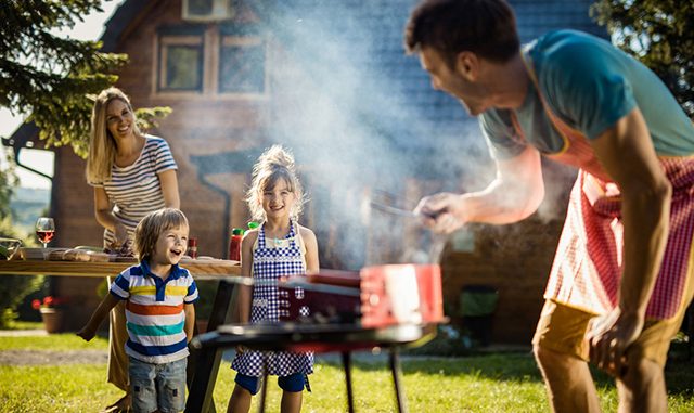 Happy kids enjoying in picnic day with their parents in the backyard.